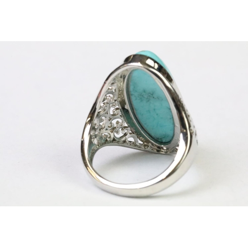 252 - A 925 Sterling silver with oval turquoise centre stone ladies ring with pieced decoration to shoulde... 