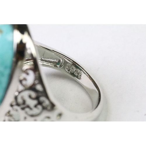 252 - A 925 Sterling silver with oval turquoise centre stone ladies ring with pieced decoration to shoulde... 