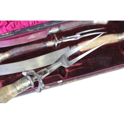 177 - A late 19th century cased carving set, antler handles with hallmarked silver mounts, dated 1896.