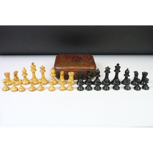 180 - A set of early 20th century boxwood chess pieces within a Huntley & Palmers biscuit tin.