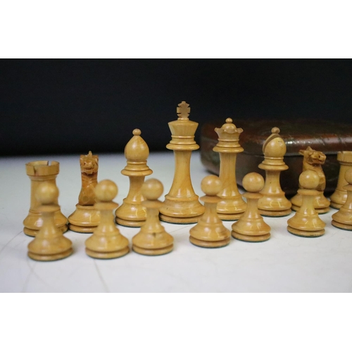 180 - A set of early 20th century boxwood chess pieces within a Huntley & Palmers biscuit tin.