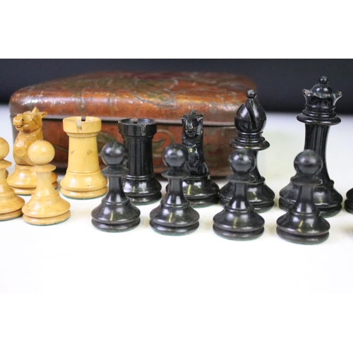 180 - A set of early 20th century boxwood chess pieces within a Huntley & Palmers biscuit tin.