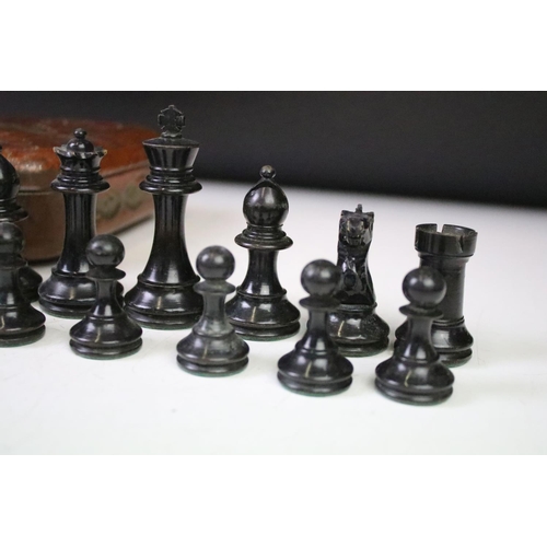 180 - A set of early 20th century boxwood chess pieces within a Huntley & Palmers biscuit tin.