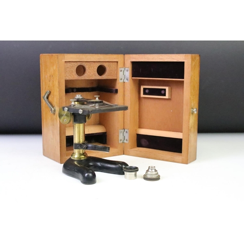 185 - An early 20th century students microscope within original fitted wooden case.