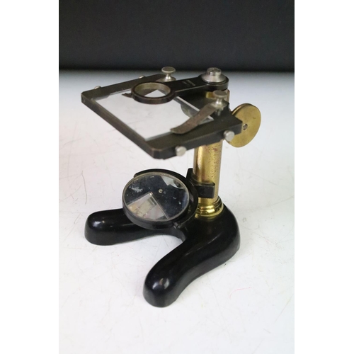 185 - An early 20th century students microscope within original fitted wooden case.