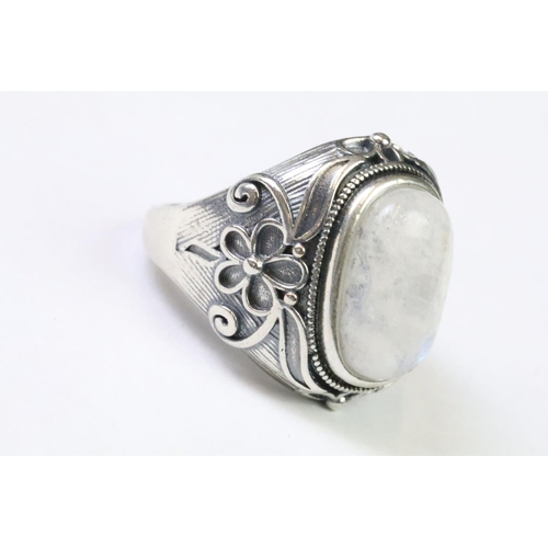 225 - A 925 Sterling silver with moonstone cabochon to centre ladies ring with decorative floral shoulders... 