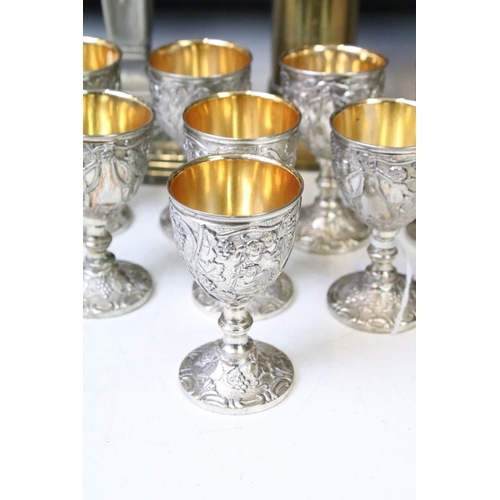 342 - Set of eight white metal drinking vessels with cast grape & vine decoration and gilt interiors (appr... 