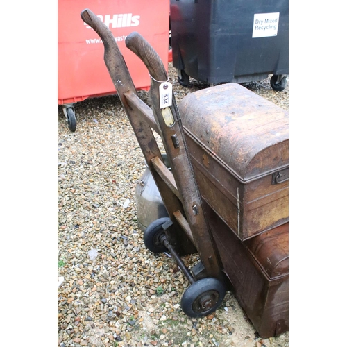 534 - Two metal trunks, together with two churns, a cast iron pot and a Slingsby wooden sack truck