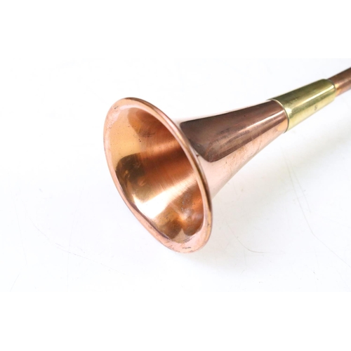 26 - Victorian copper hunting horn having a brass mouth piece and brass banding. Measures 42.5cm.