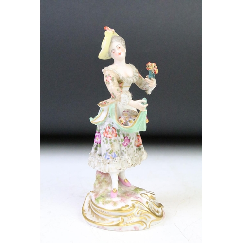 35 - Continental porcelain figurine of a female holding flowers, with hand painted floral decoration, gil... 