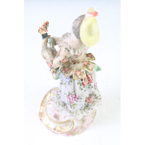 35 - Continental porcelain figurine of a female holding flowers, with hand painted floral decoration, gil... 