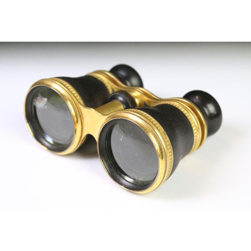 28 - A pair of mid 20th century leather clad binoculars with decorative gilt decoration housed within a s... 