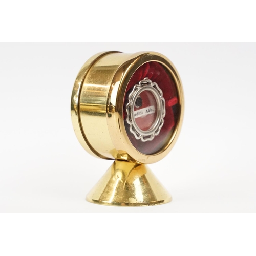 254 - A Religious relic of S. Benedicti Abb. housed within a circular brass display case.