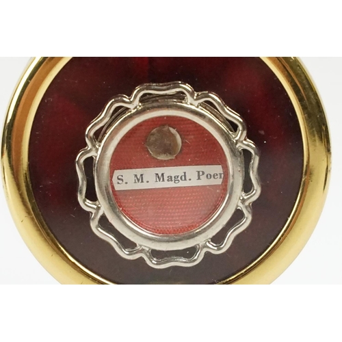 257 - A religious relic of S. M. Magd. Poer. housed within  a circular brass display case.