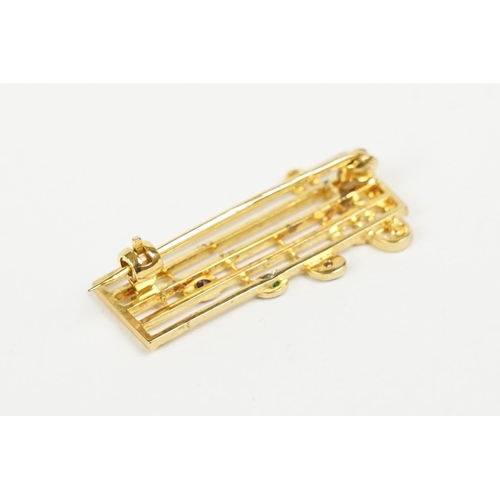 259 - A ladies hallmarked 9ct gold brooch in the form of musical notes.