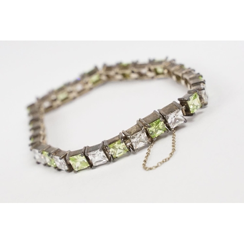 268 - A contemporary 925 sterling silver tennis bracelet set with light green and clear stones, complete w... 