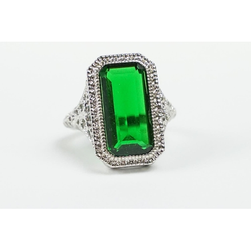 279 - A 925 sterling silver ladies dress ring of classical style with green centre stone raised to pieced ... 