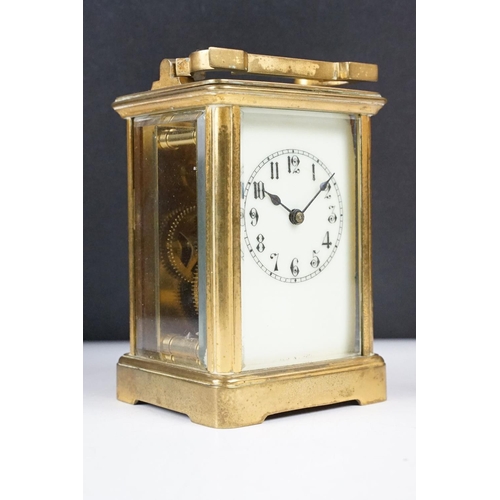 288 - An antique 19th century brass cased carriage clock with beveled glass panels, complete with key.