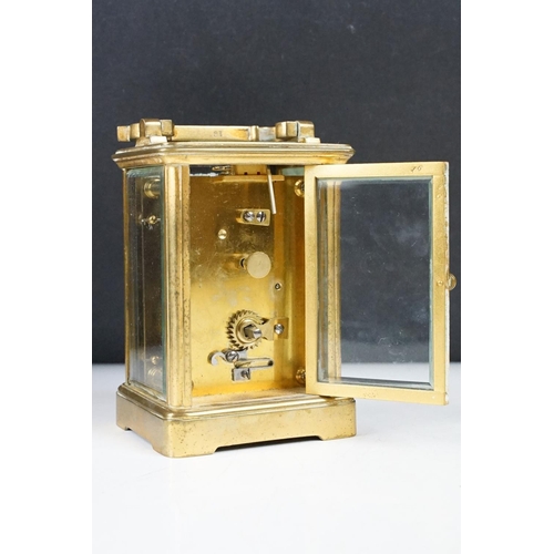 288 - An antique 19th century brass cased carriage clock with beveled glass panels, complete with key.