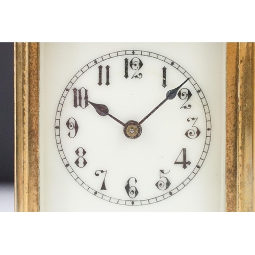 288 - An antique 19th century brass cased carriage clock with beveled glass panels, complete with key.