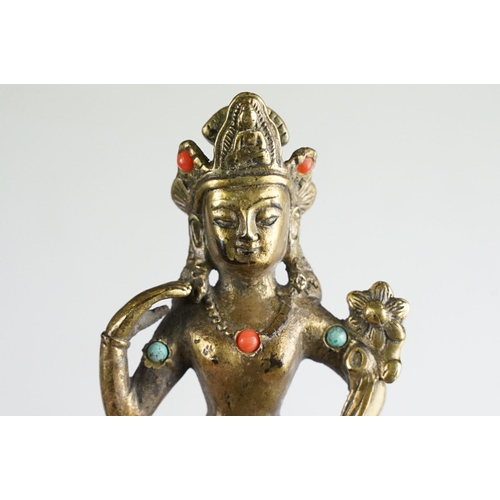 138 - Chinese gilt metal Buddhist figure with jewelled detail, raised on a hardwood stand with four feet. ... 