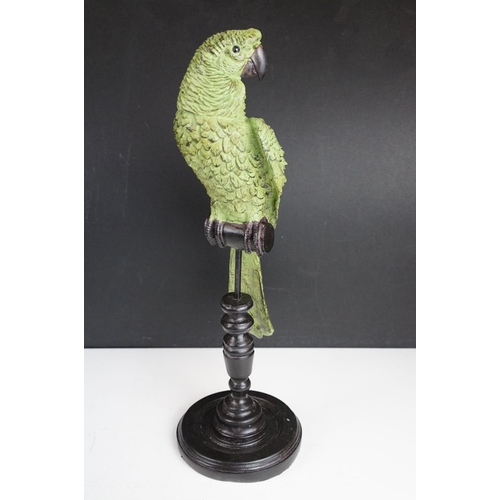 143 - Bronze figure of a green bird, possibly a crane, raised on a circular wooden plinth (approx 22.5cm h... 