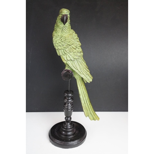 143 - Bronze figure of a green bird, possibly a crane, raised on a circular wooden plinth (approx 22.5cm h... 