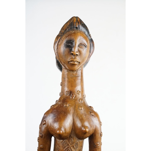 145 - Carved African hardwood figure of a stylised female holding a bottle & vessel (approx 42cm tall), to... 