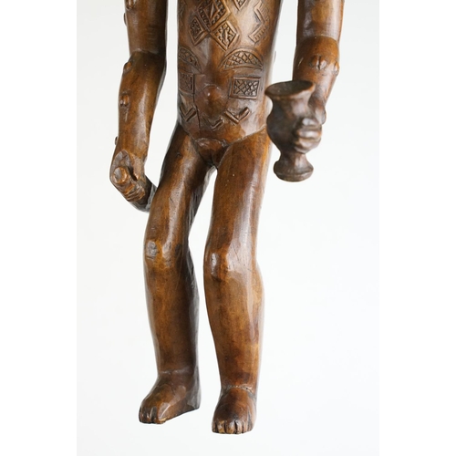 145 - Carved African hardwood figure of a stylised female holding a bottle & vessel (approx 42cm tall), to... 