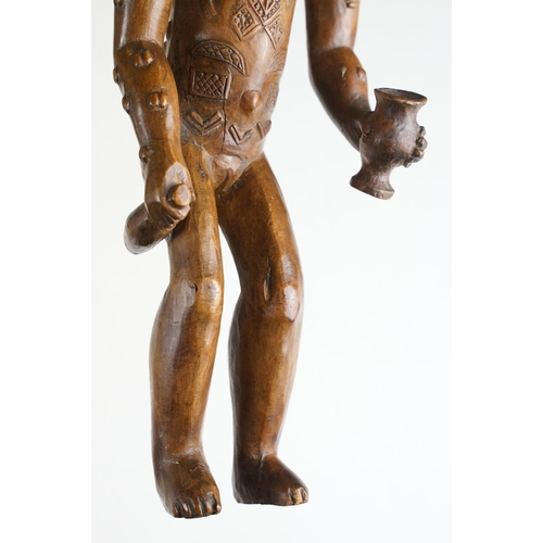 145 - Carved African hardwood figure of a stylised female holding a bottle & vessel (approx 42cm tall), to... 