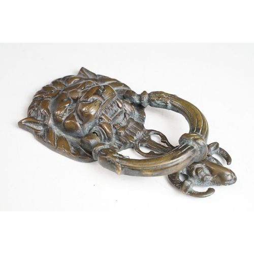 148 - Victorian cast metal door knocker having a lions head back plate with goat head suspended below and ... 