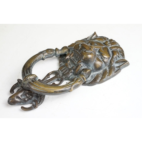 148 - Victorian cast metal door knocker having a lions head back plate with goat head suspended below and ... 