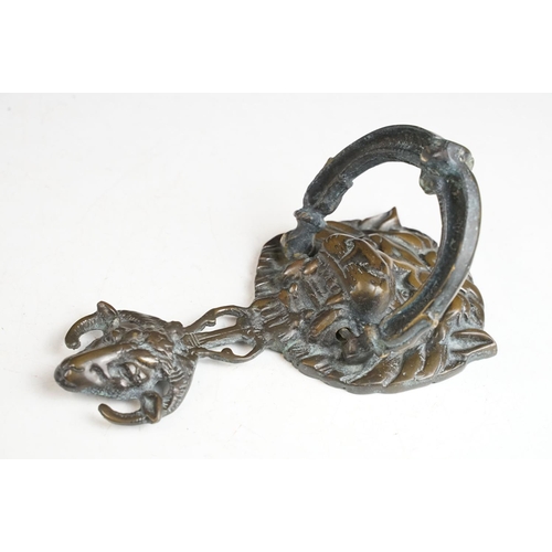 148 - Victorian cast metal door knocker having a lions head back plate with goat head suspended below and ... 