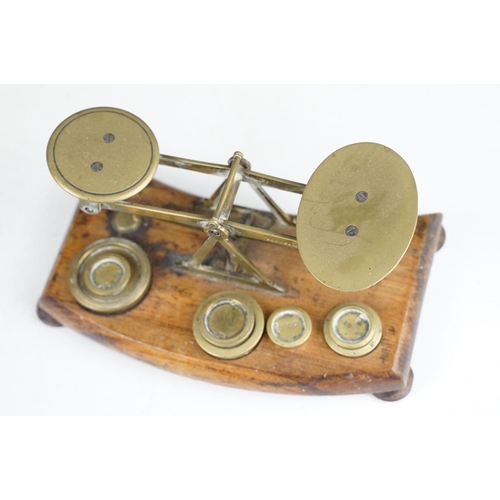 172 - Pair of early 20th Century small desk top balance scales having seven brass oz weights, raised on a ... 