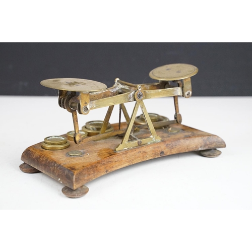 172 - Pair of early 20th Century small desk top balance scales having seven brass oz weights, raised on a ... 