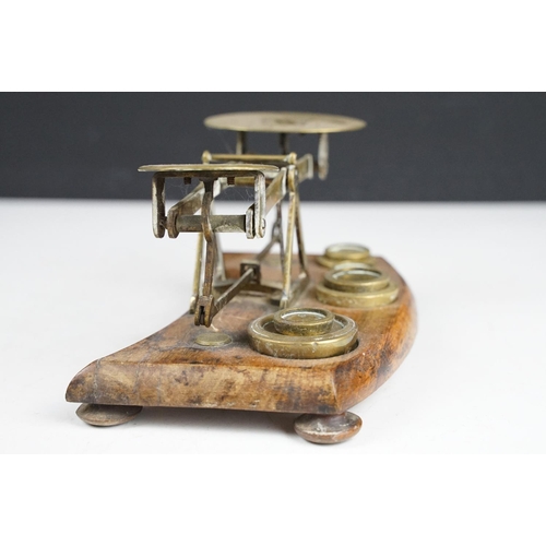 172 - Pair of early 20th Century small desk top balance scales having seven brass oz weights, raised on a ... 