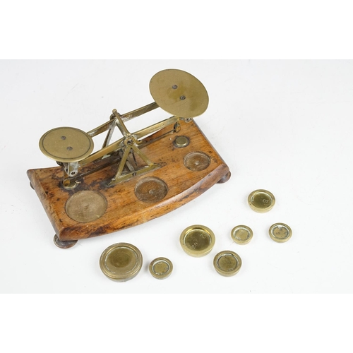 172 - Pair of early 20th Century small desk top balance scales having seven brass oz weights, raised on a ... 