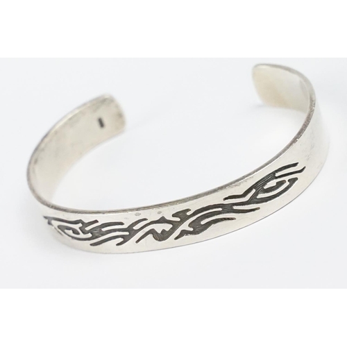 284 - A contemporary 925 sterling silver open ended cuff bangle with engraved tribal decoration, marked 92... 