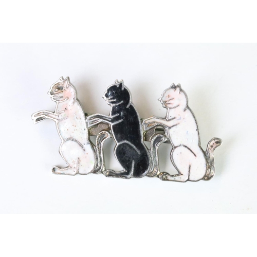 120 - A silver plated and enamel brooch in the form of three seated cats.