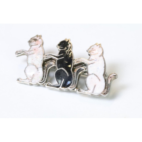 120 - A silver plated and enamel brooch in the form of three seated cats.