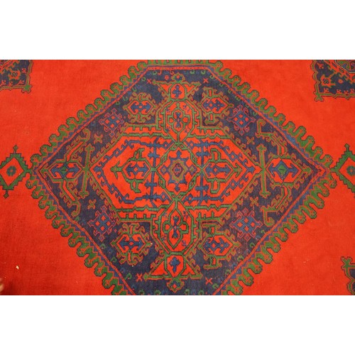 613 - Large Wool Red Ground Rug with central geometric pattern motif and border to edge, 320cm x 373cm