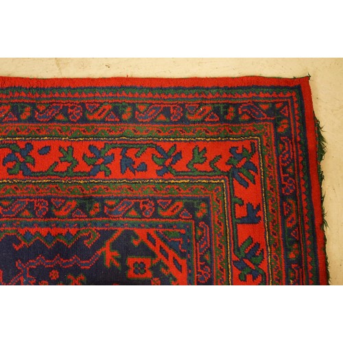 613 - Large Wool Red Ground Rug with central geometric pattern motif and border to edge, 320cm x 373cm