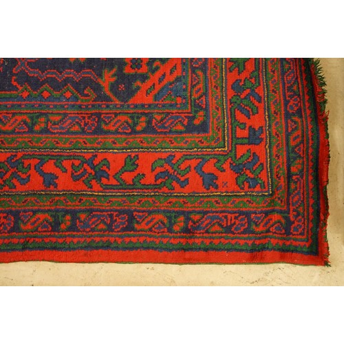 613 - Large Wool Red Ground Rug with central geometric pattern motif and border to edge, 320cm x 373cm