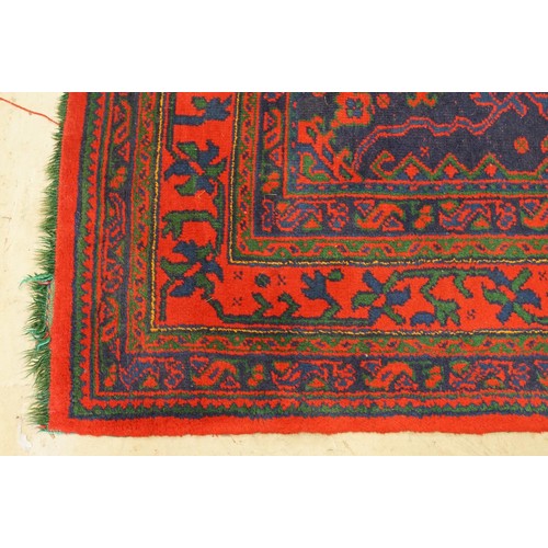 613 - Large Wool Red Ground Rug with central geometric pattern motif and border to edge, 320cm x 373cm