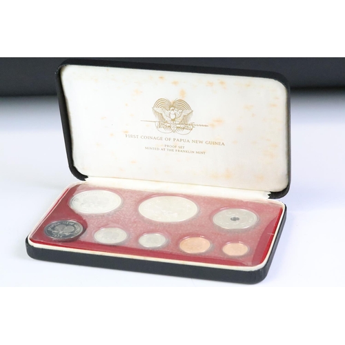 49 - A collection of three Franklin Mint proof coin sets to include The first coinage of Papua New Guinea... 