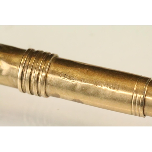 153 - 9ct gold cigar piercer having banded detailing. Hallmarked Birmingham 1910. Measures 8.3cm.