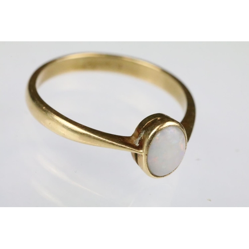 160 - Yellow gold and opal single stone ring bezel set with an oval opal cabochon to a plain band with pin... 