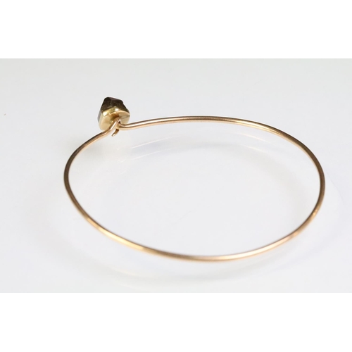 248 - Rose gold bangle bracelet having a hook clasp set with a smokey quartz crystal. Unmarked, assessed a... 