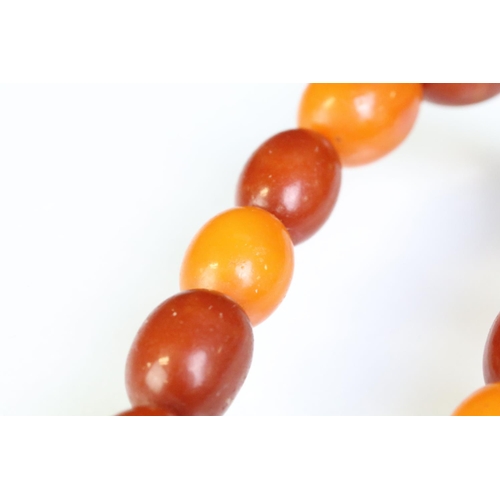 249 - Amber beaded necklace constructed from oval drilled amber beads. Measures 24 inches. Sample bead mea... 