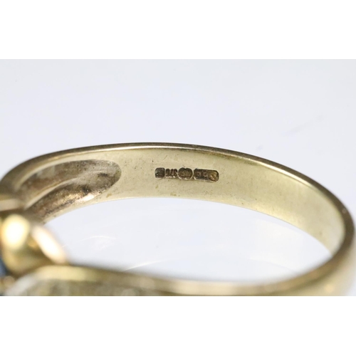 201 - 9ct gold hallmarked cross over ring set with an oval cut clue stone (hallmarked London, size T.5), t... 